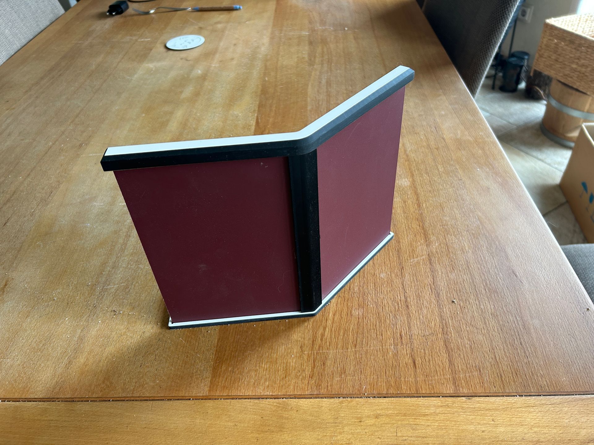 Ein rotes Buch liegt auf einem Holztisch