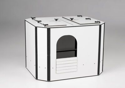 Auf einem Holztisch steht ein weißes Katzenhaus.