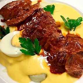 Lomo Saltado con salsa cremosa, huevo y guarnición de perejil.