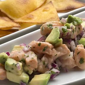 Ceviche de salmón con aguacate y cebolla morada, servido con tortillas chips.
