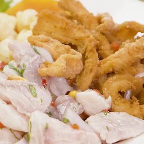 Ceviche y mariscos fritos con papas y rodaja de camote amarillo.