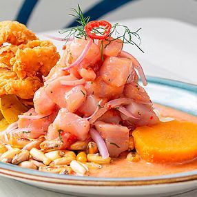 Ceviche con mariscos fritos, cebolla, maíz, camote y chile en un plato.