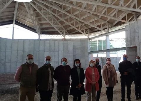 Un grupo de personas que llevan mascarillas se encuentran en un edificio en construcción.