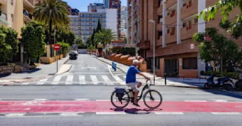 Un hombre va en bicicleta por una calle de la ciudad.