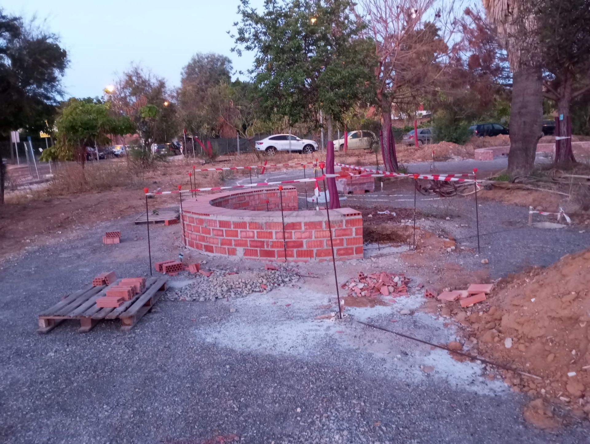 Se está construyendo un muro de ladrillos en una zona de tierra.