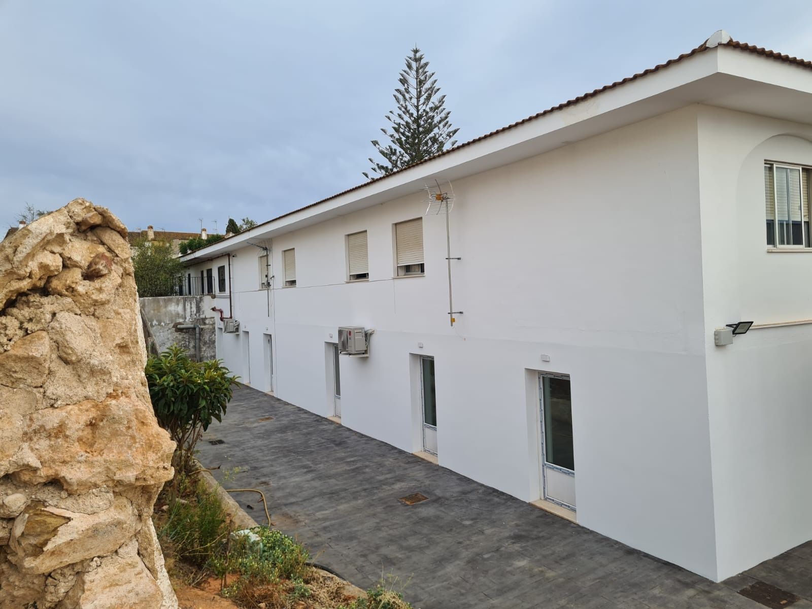 Un edificio blanco con muchas ventanas y techo.