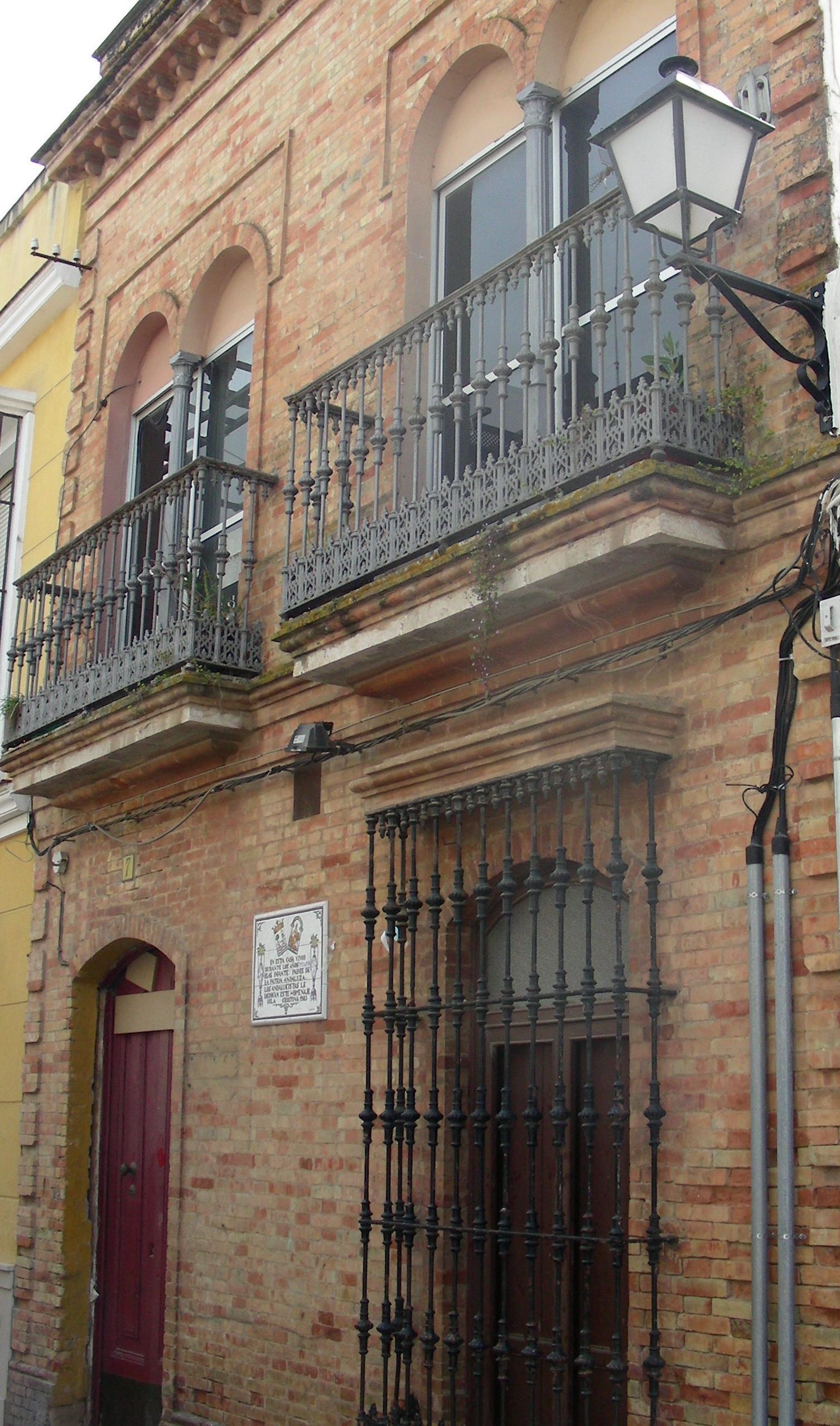 Un edificio de ladrillo con balcón y farola.