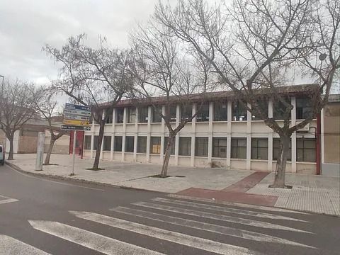 Un edificio con muchas ventanas y árboles delante de él.