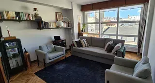 Una sala de estar con un sofá, sillas y una alfombra.