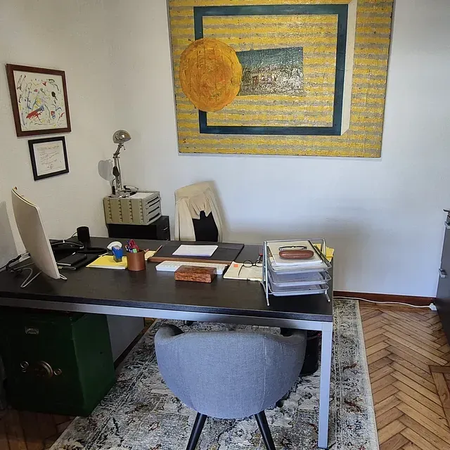 Una habitación con un escritorio y una silla y un cuadro en la pared.