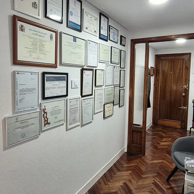Un pasillo con muchos certificados en la pared.