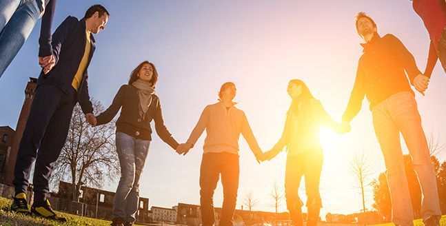 Un grupo de personas se toman de la mano en un círculo.