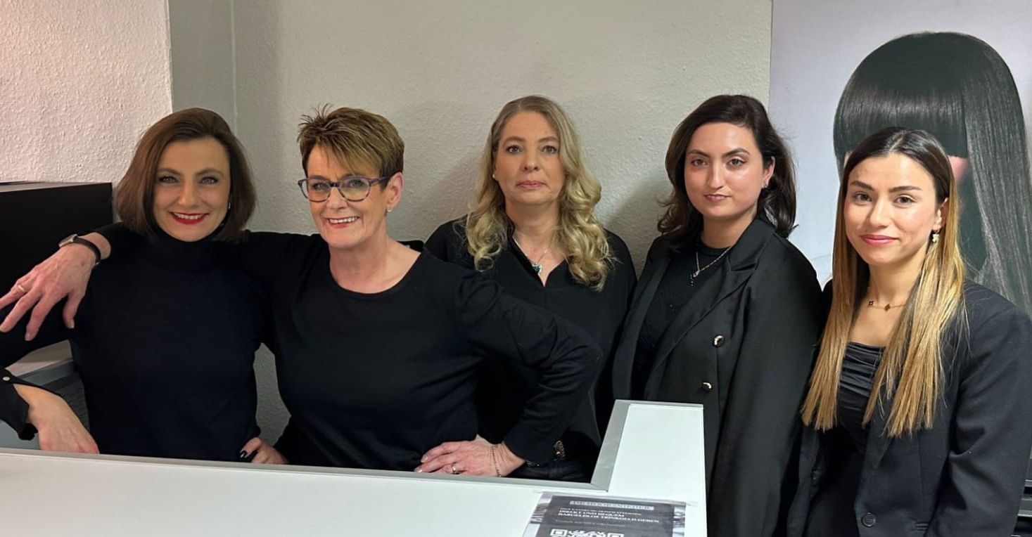 Eine Gruppe von Frauen posiert in einem Salon für ein Foto.