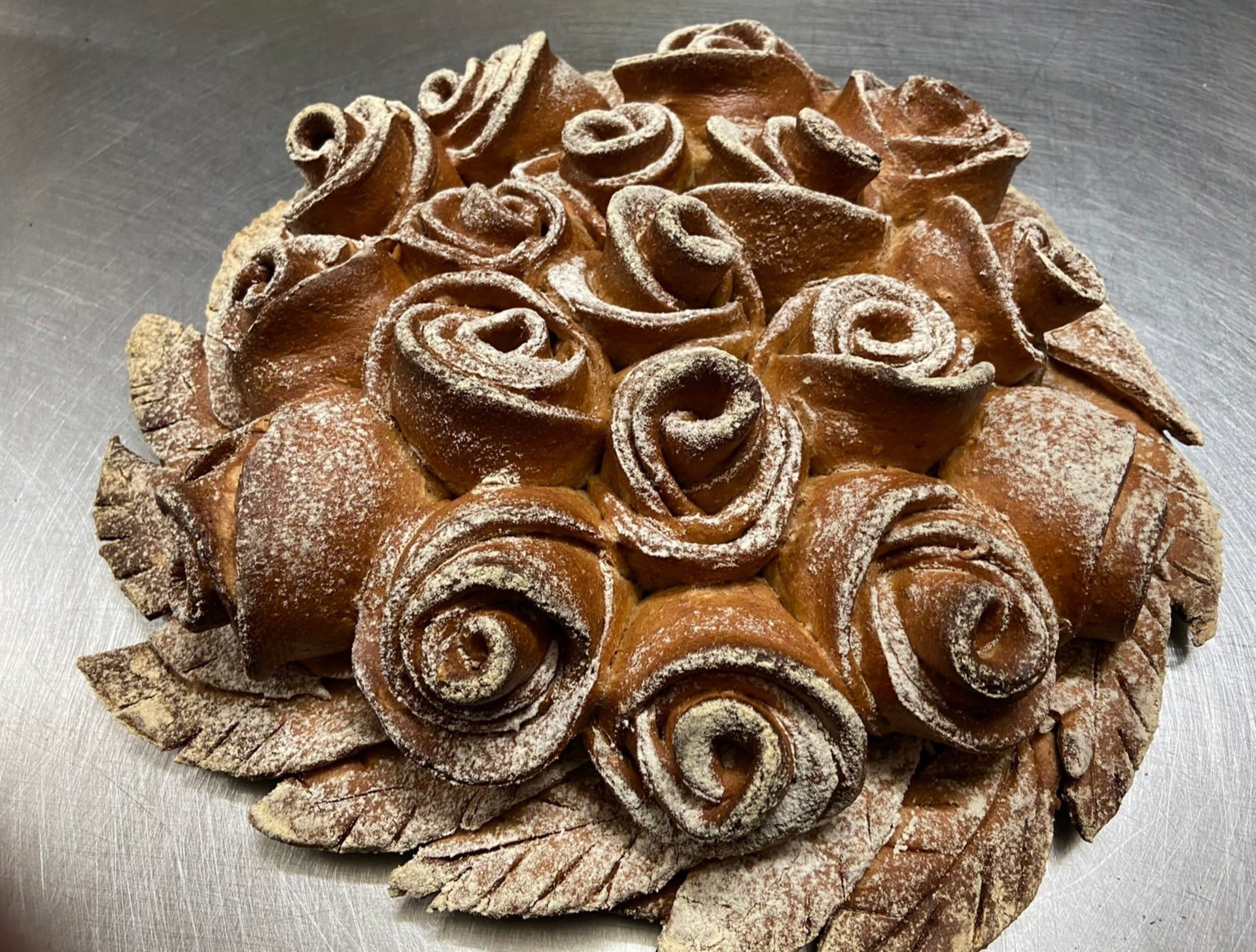 Pagnotta di pane croccante e oblungo, spolverata di farina bianca.
