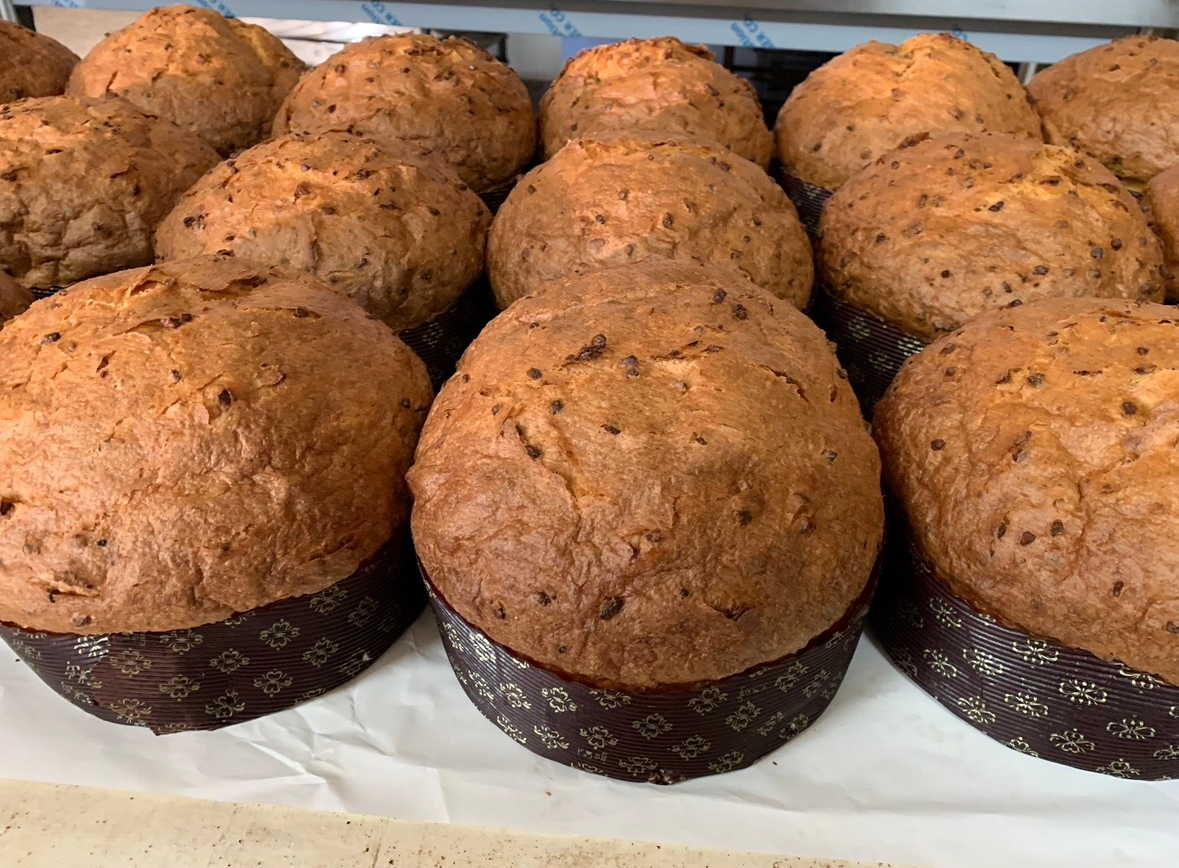 Crostate di frutta in esposizione, con fichi, fragole e lamponi. Le crostate dorate sono disposte su un vassoio di metallo.