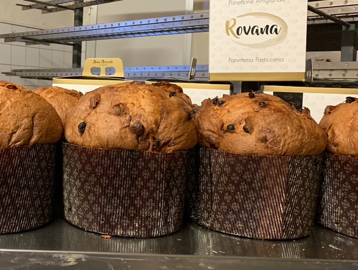 Crostate di frutta in esposizione, con fichi, fragole e lamponi. Le crostate dorate sono disposte su un vassoio di metallo.