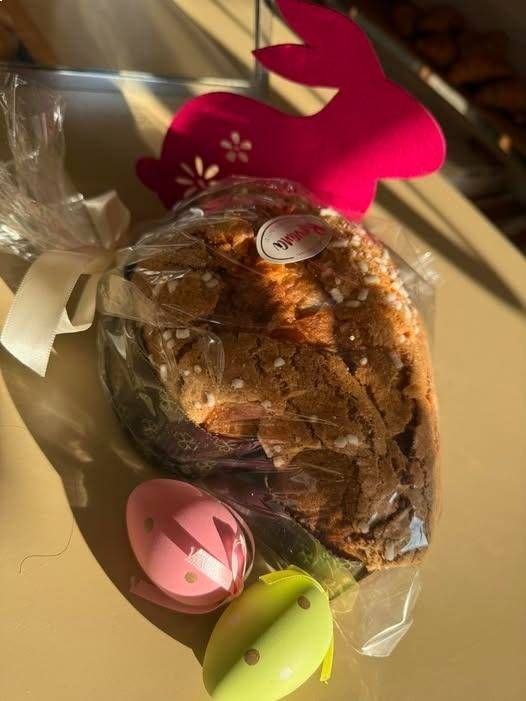 Confezione regalo di dolcetti pasquali con un coniglietto rosa e due uova dipinte.