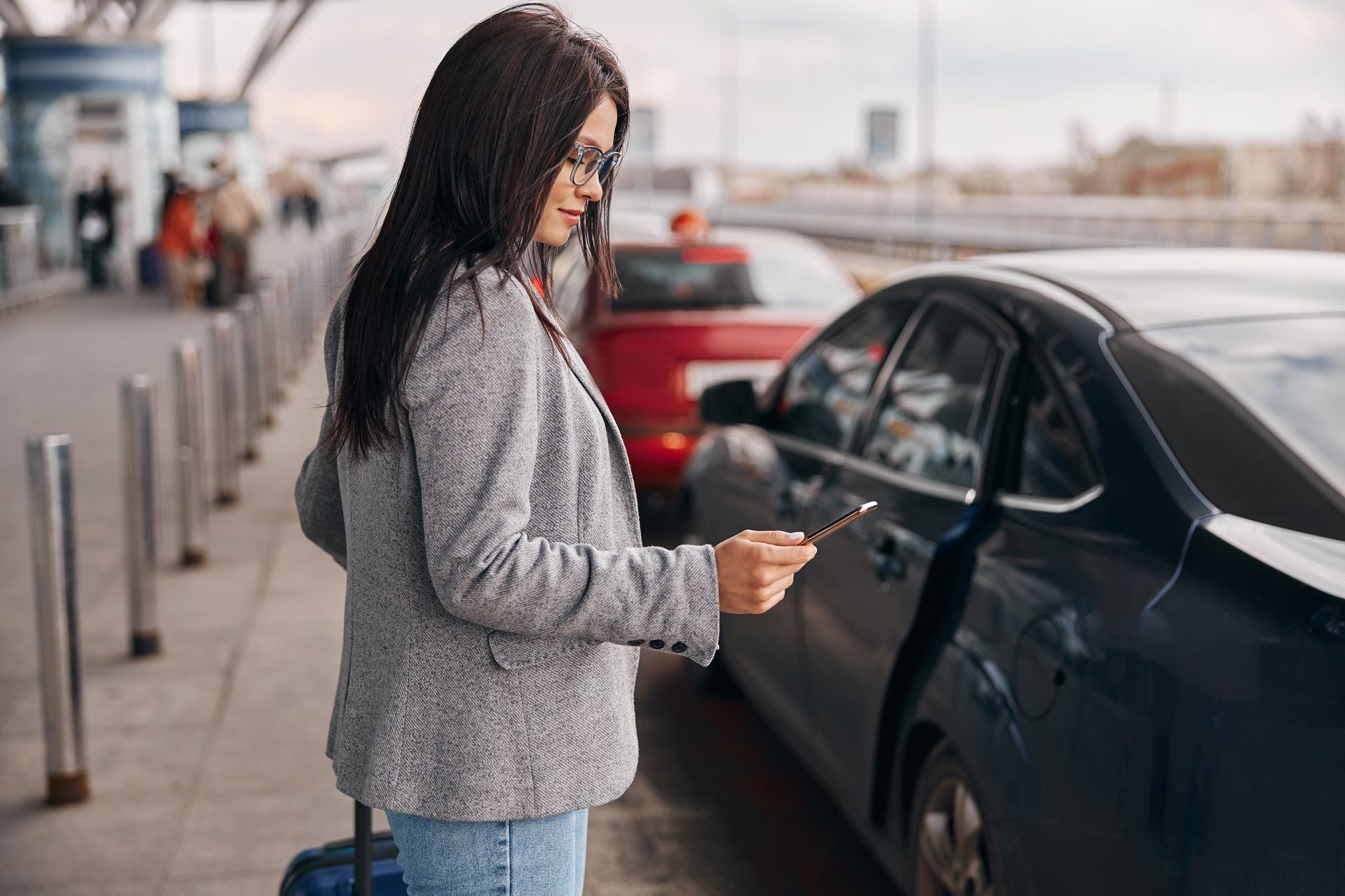 Une femme devant une voiture.