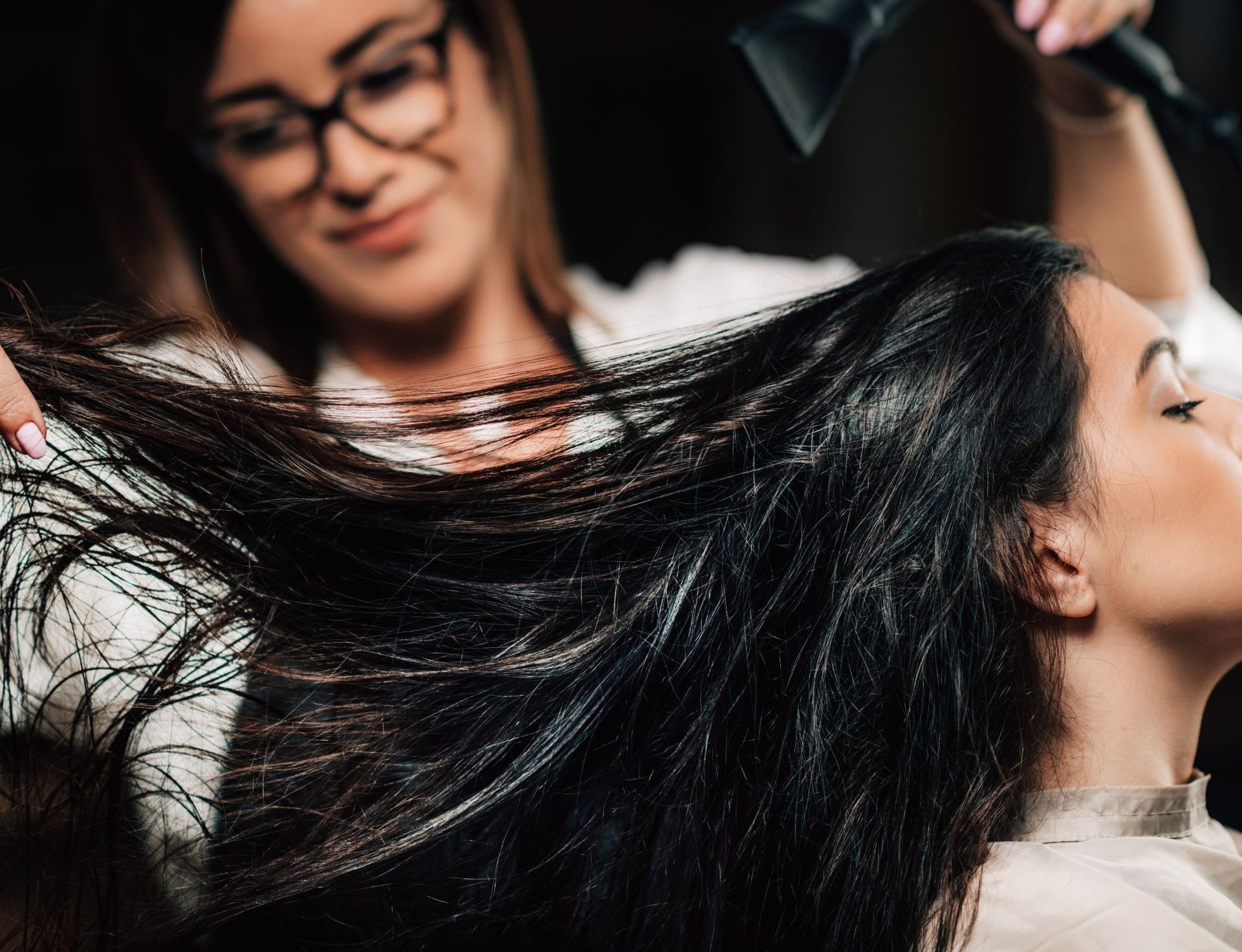 Una mujer se está secando el pelo con un secador en la peluquería.