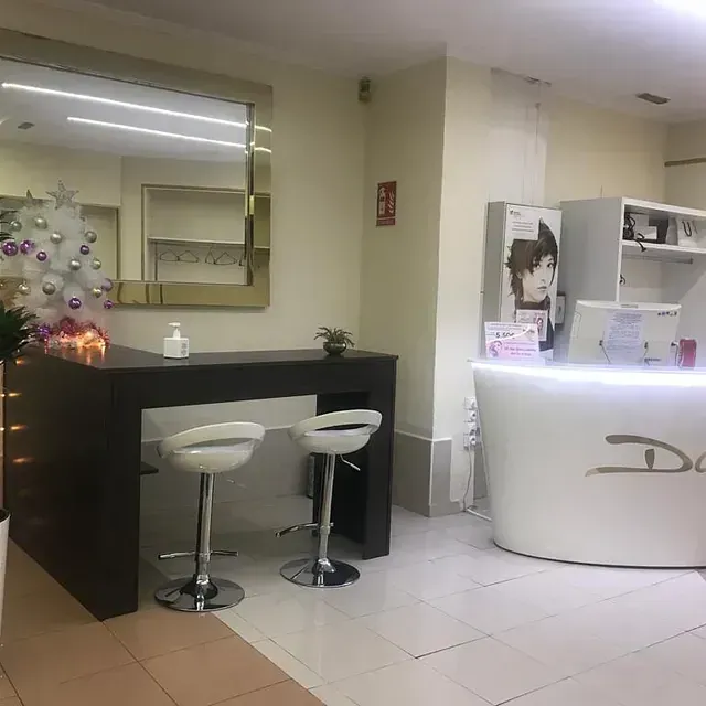 Una habitación con una mesa, taburetes, un espejo y un árbol de navidad.