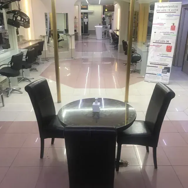 Un salón con una mesa redonda y sillas.