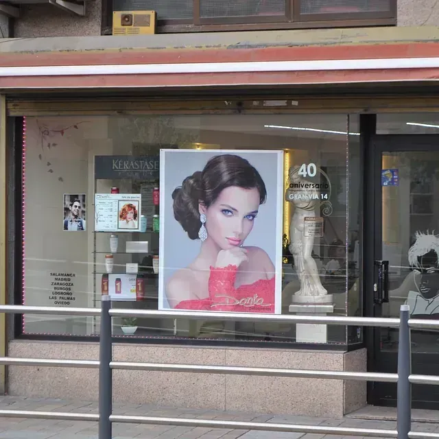 Una foto de una mujer con un vestido rojo cuelga en el escaparate de una tienda.