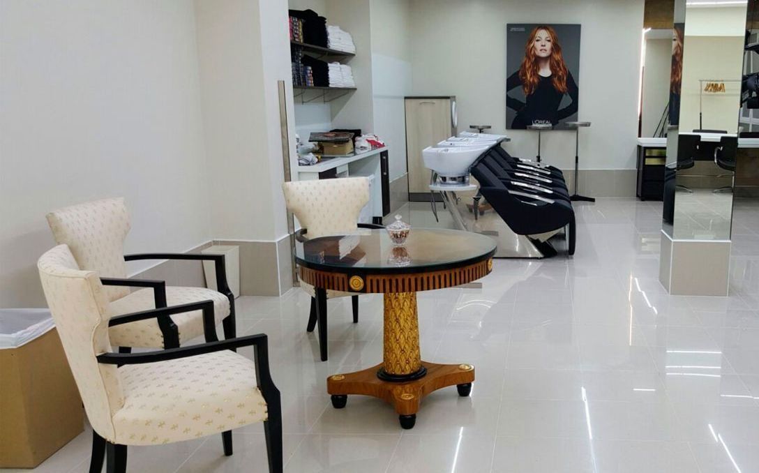 Un salón con una mesa y sillas y un lavabo.