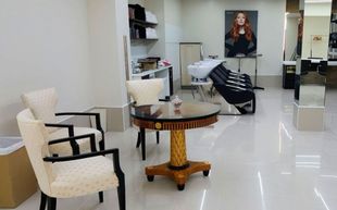 Un salón con una mesa y sillas y un lavabo.