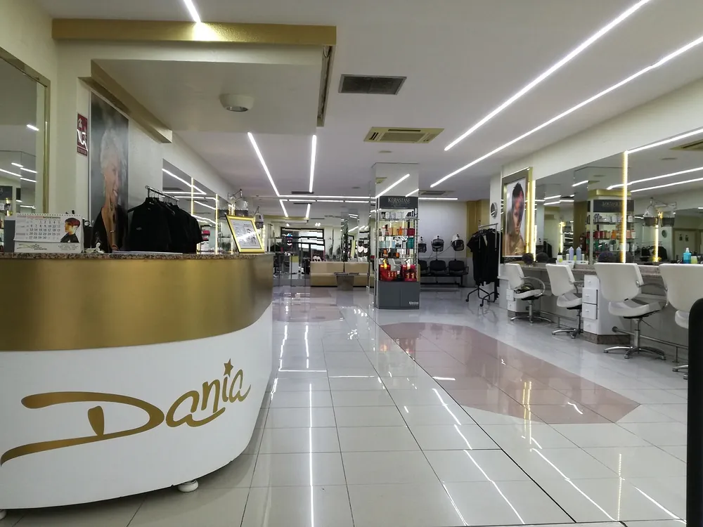 El interior de una peluquería con un mostrador dorado y blanco.