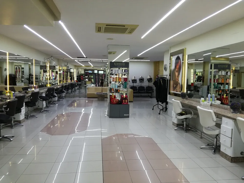 Una gran peluquería con muchas sillas y espejos.