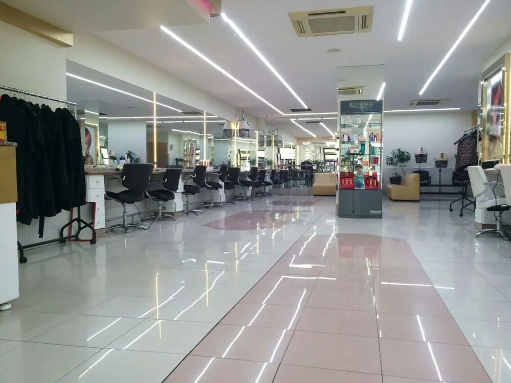 Un largo pasillo en una peluquería con suelo de baldosas rosas.