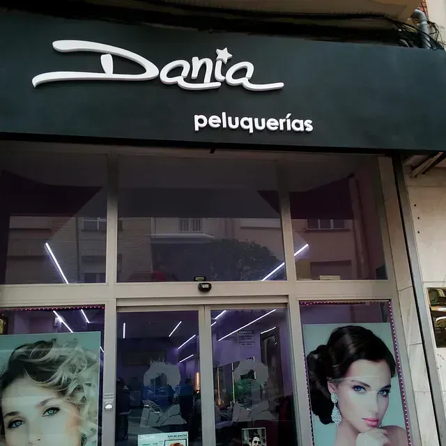Un escaparate con un cartel que dice 'dania peluqueria'