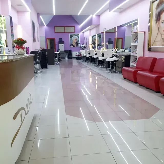 Un salón con paredes moradas y sillas blancas.