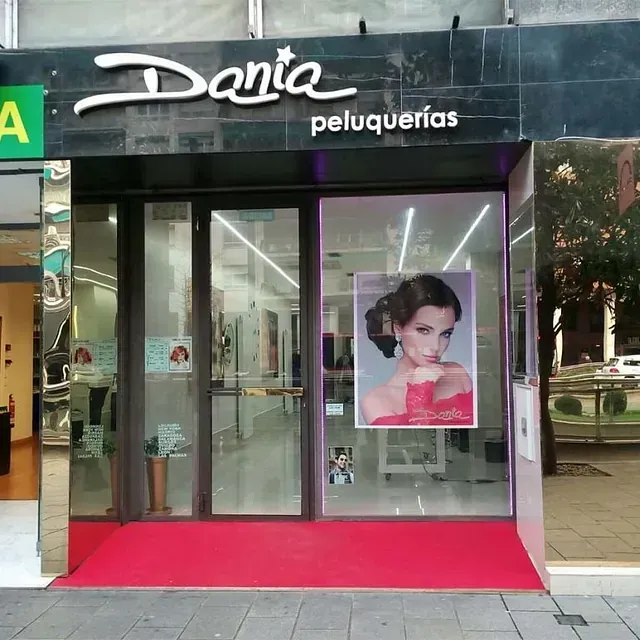 Danta Peluquería tiene una foto de una mujer en la ventana.