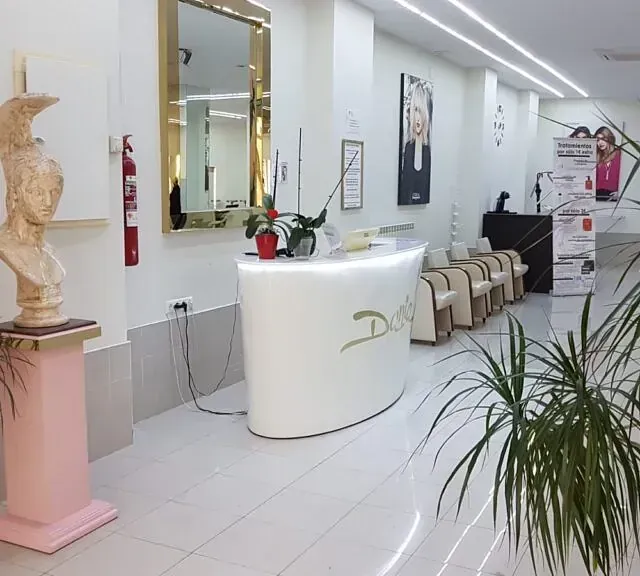 Un mostrador blanco en una habitación con una estatua en un pedestal.