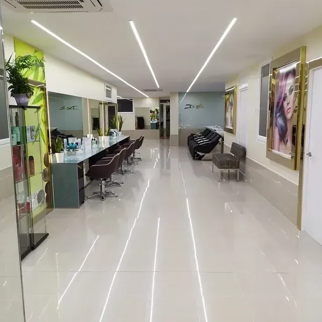 Un largo pasillo en un salón con sillas y espejos.