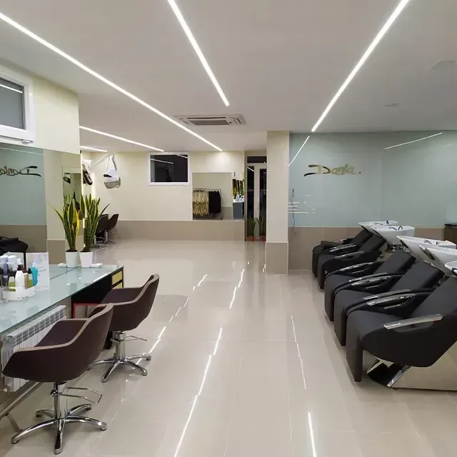 Un salón con muchas sillas y lavabos.