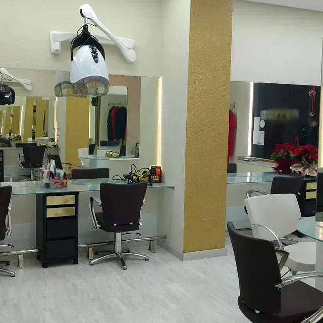 Una peluquería con muchas sillas y espejos.