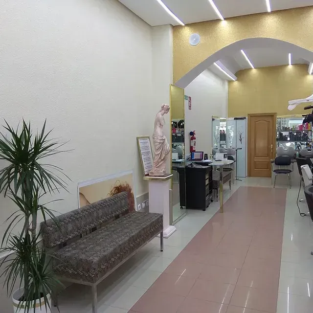 Una estatua de una mujer se sienta en un pedestal en un pasillo.