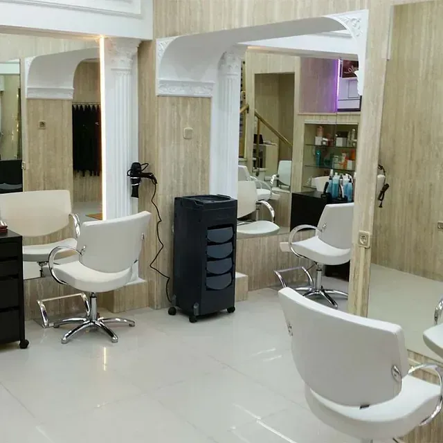 Una peluquería con muchas sillas y espejos.