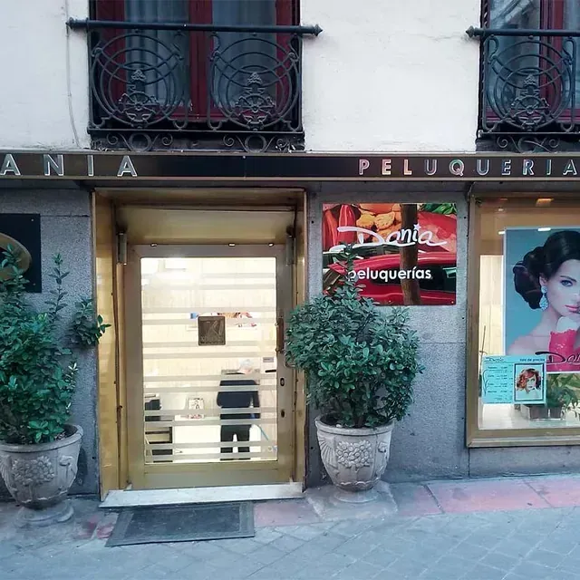 Un edificio con un cartel que dice Ania Peluquería.