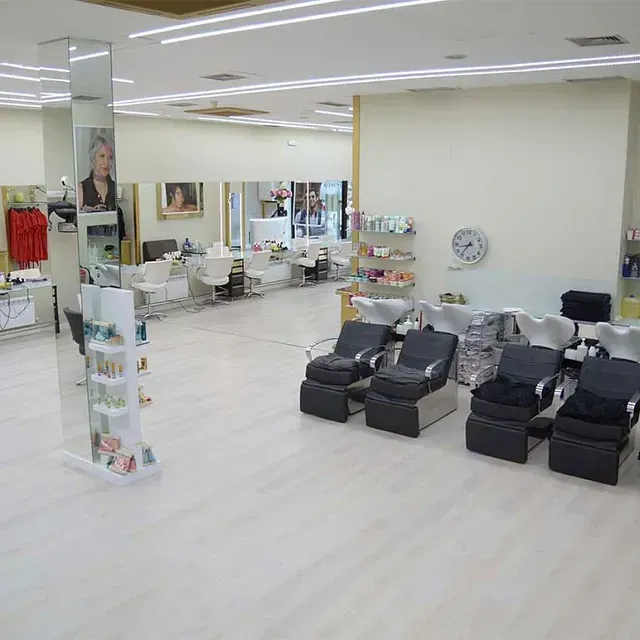 Una habitación grande con muchas sillas y lavabos.