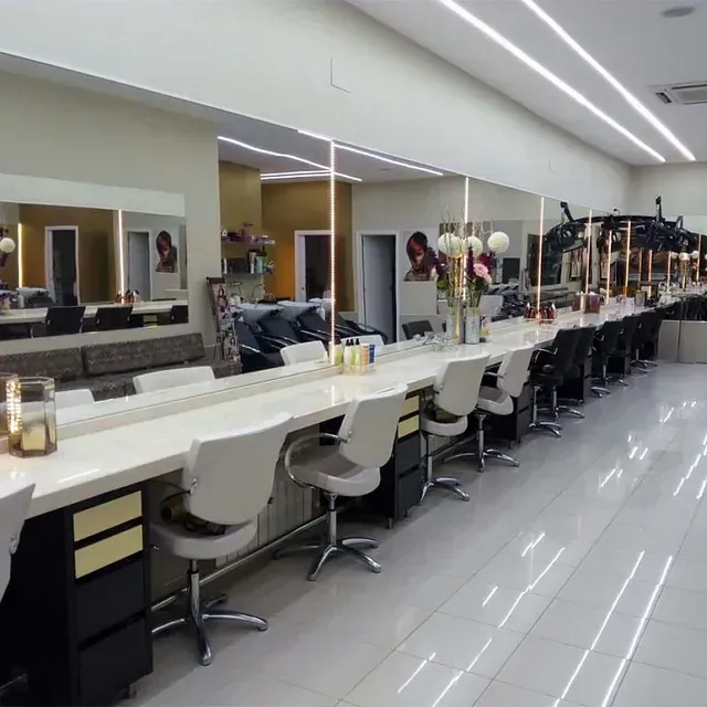 Una larga fila de sillas en una peluquería