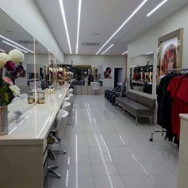 Una habitación grande con muchos espejos y ropa colgada.