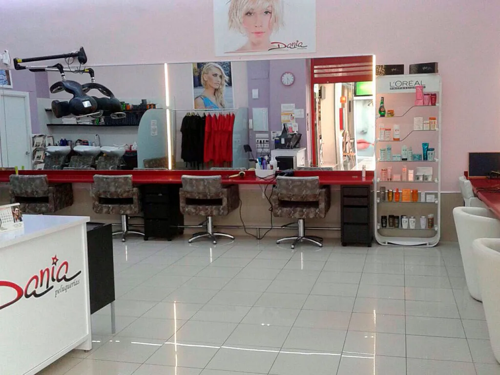 Una peluquería con una foto de mujer en la pared.