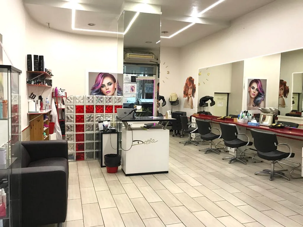 Una peluquería con muchas sillas y espejos.