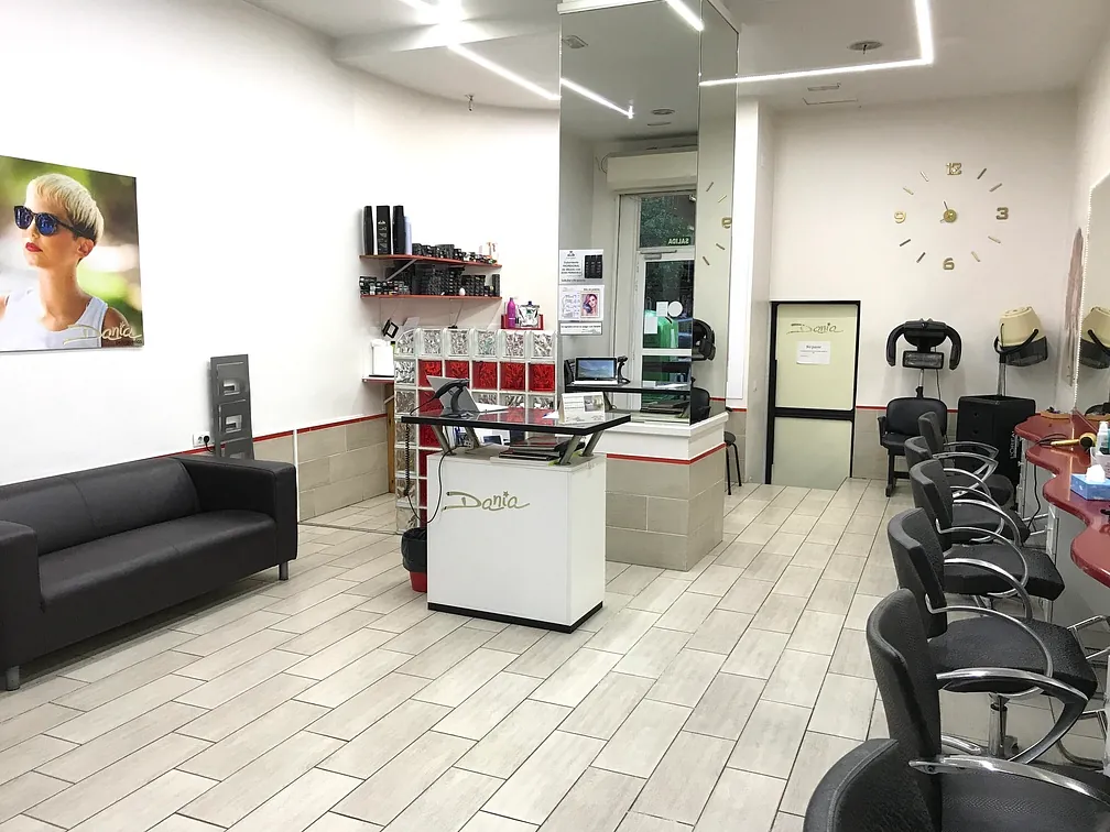 Un salón con un sofá, sillas y un reloj en la pared.