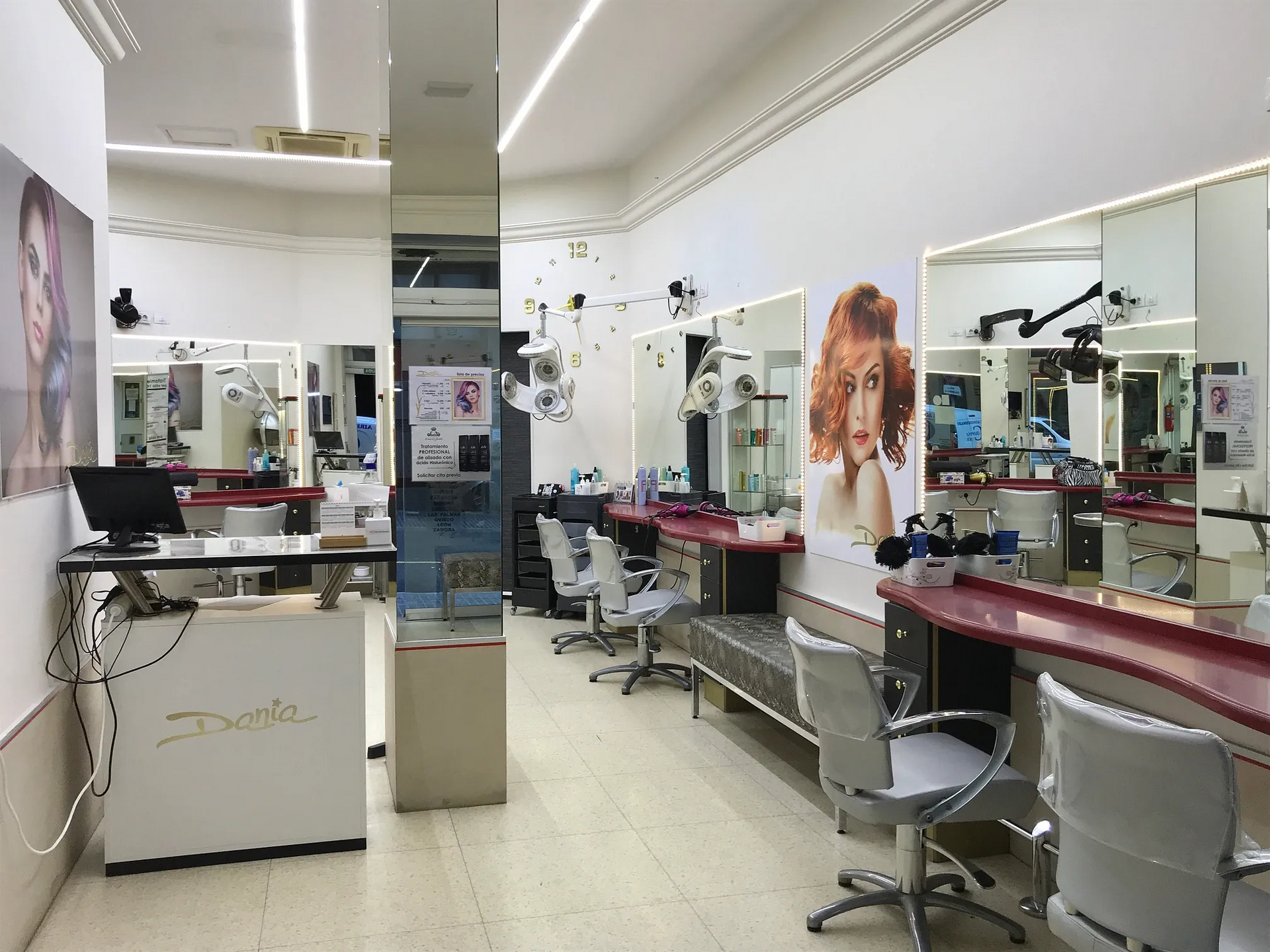 Una peluquería con muchas sillas y espejos.