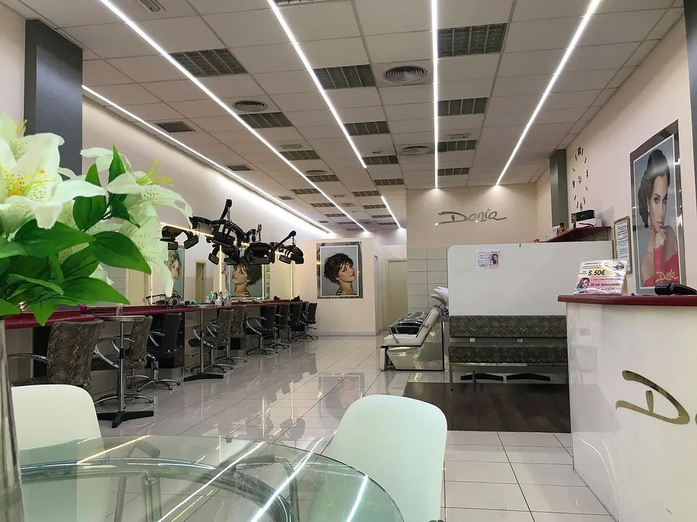 Un salón con una mesa y sillas y una flor en primer plano