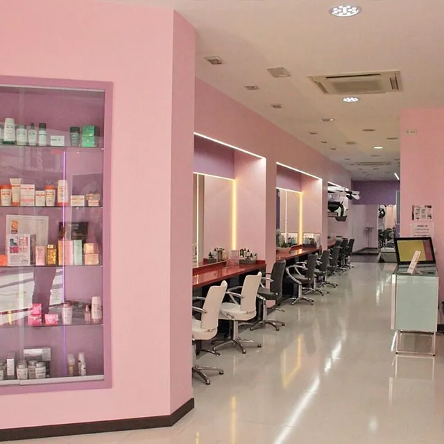 Una peluquería con paredes y sillas rosas.